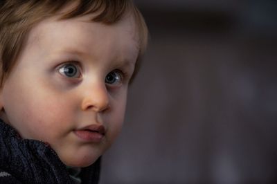 Close-up portrait of cute boy with cross-eyed outdoors