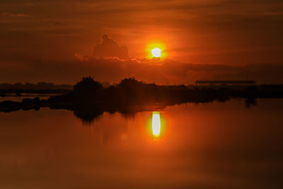 Scenic view of lake against orange sky