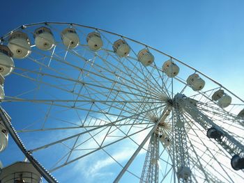 Low angle view of ferris wheel against blue sky