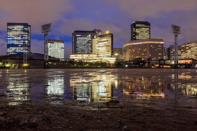 Illuminated buildings in city against sky at night