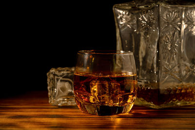 Close-up of wine glass on table against black background