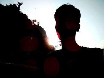 Rear view portrait of silhouette man playing against sky during sunset