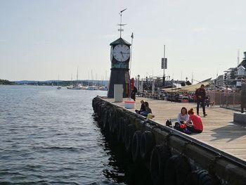 People at sea shore against sky