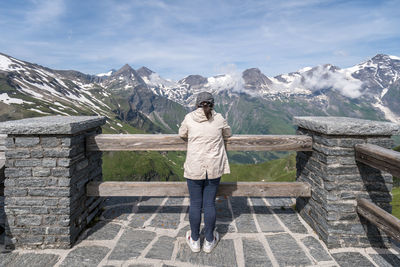 Rear view of woman looking at snowcapped mountain against sky