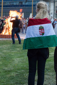 Rear view of people with fire on the background