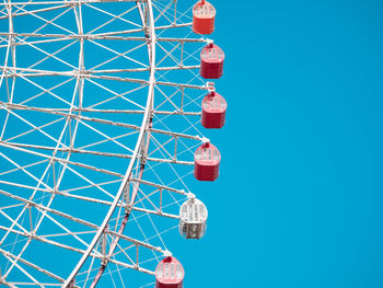 Low angle view of ferris wheel against clear blue sky