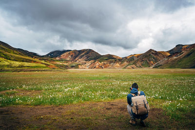 Rear view of man on field against sky