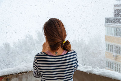 Rear view of woman looking at snow outdoors