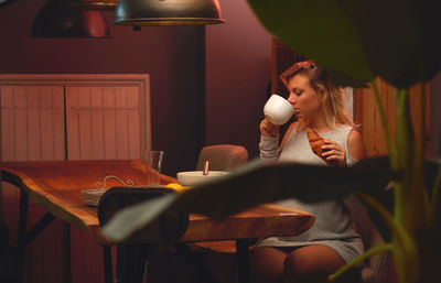 Woman sitting on table at home