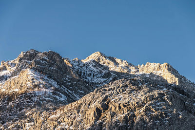 Low angle view of mountains against clear blue sky