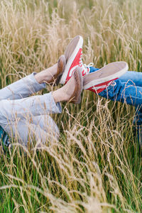 Low section of playful children lying on grassy land