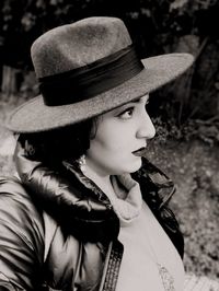 Close-up of thoughtful young woman wearing hat while standing outdoors