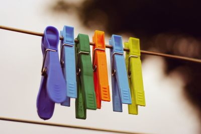 Close-up of colorful pegs hanging on clothesline