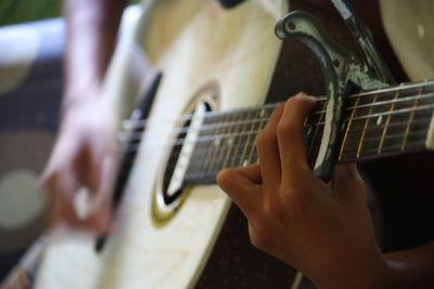 Close-up of hands playing guitar