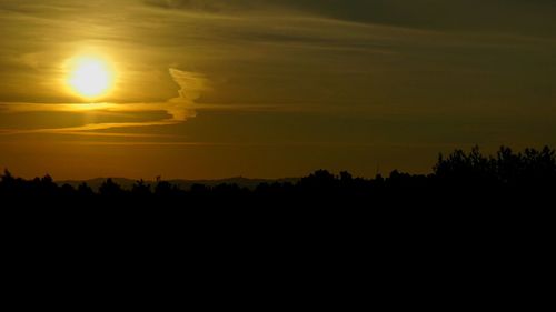 Scenic view of silhouette landscape against orange sky