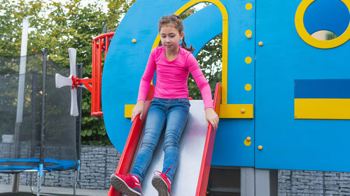 Full length of girl sliding in playground