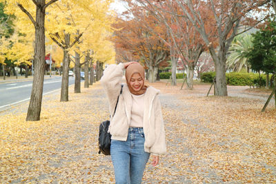 Portrait of young woman standing on road