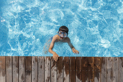 Shirtless boy swimming in pool