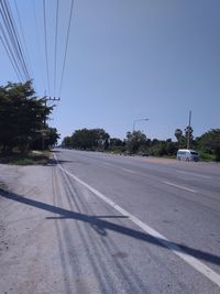 Cars on road against clear sky in city