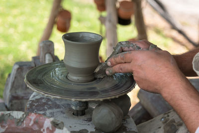 Cropped hand of man working with pottery