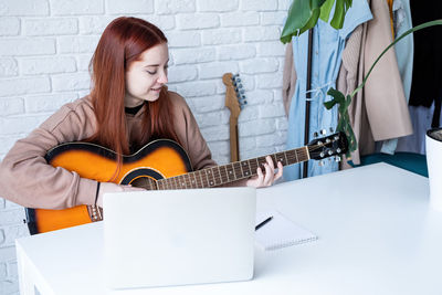 Portrait of young woman using laptop at home