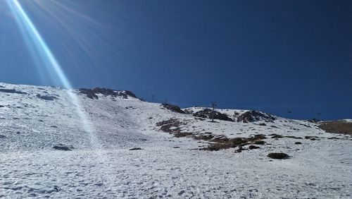 Scenic view of snowcapped mountains against clear blue sky