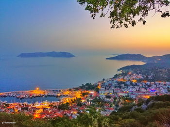 Aerial view of townscape by sea against sky during sunset