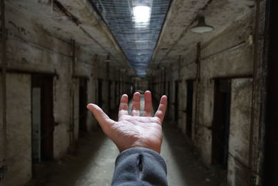 Cropped hand of man gesturing in corridor