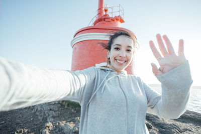 Cropped hand of man with arms raised against sky