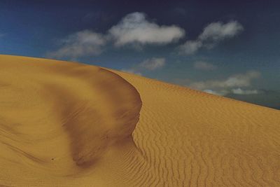 Sand dune in desert against sky