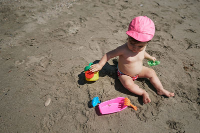 A baby playing with beach toys in the sand. vacation concept