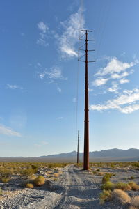 Electrical power poles and power lines along dirt road  power line road in pahrump, nevada, usa