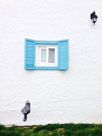 Rear view of person walking by white building