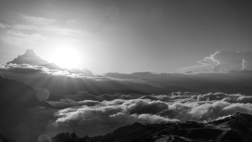 Low angle view of sunlight streaming through clouds