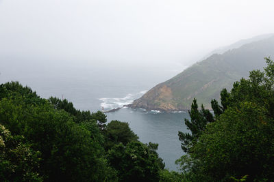 Scenic view of sea and mountains against sky