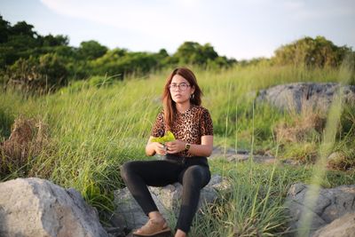 Full length of woman sitting on field