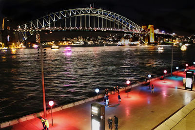 Illuminated bridge over river at night