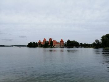 Scenic view of lake by building against sky