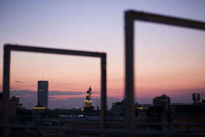 Buildings in city against sky at sunset