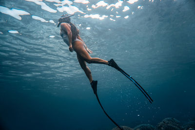 Low angle view of mid adult woman swimming in sea