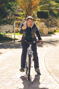 Portrait of man riding bicycle on footpath