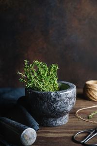 Close-up of herbs in mortar and pestle on table