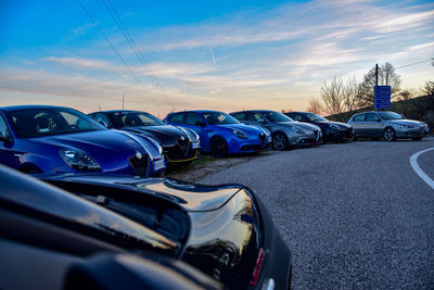 Cars parked on road against blue sky