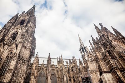 Low angle view of cologne cathedral against cloudy sky
