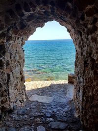 Scenic view of sea seen through arch