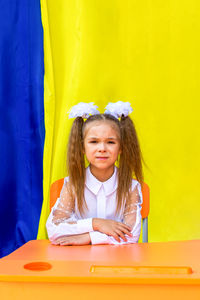 Lisichansk, ukraine. september 1, 2021  a girl with white bows and a white blouse looks at the camer