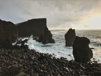 Scenic view of sea and waves splashing on shore against sky