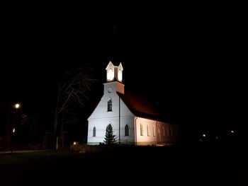 Illuminated building against sky at night