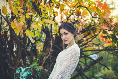 Beautiful girl in a white lace blouse in an autumn park