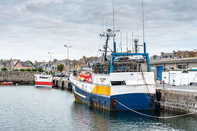 View of fishing boats moored at harbor